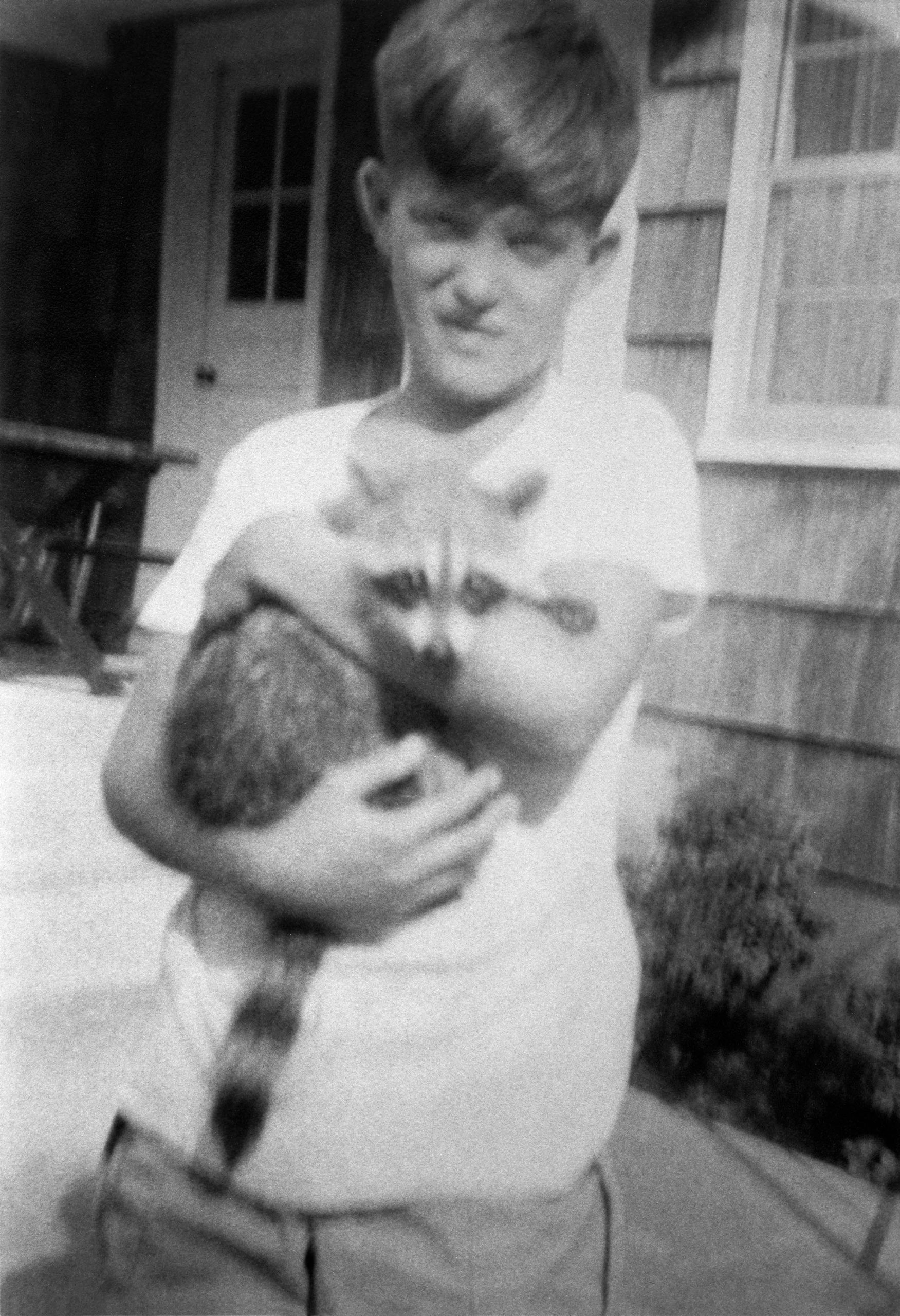 Black and White photo of young Doug with a racoon named Frankie